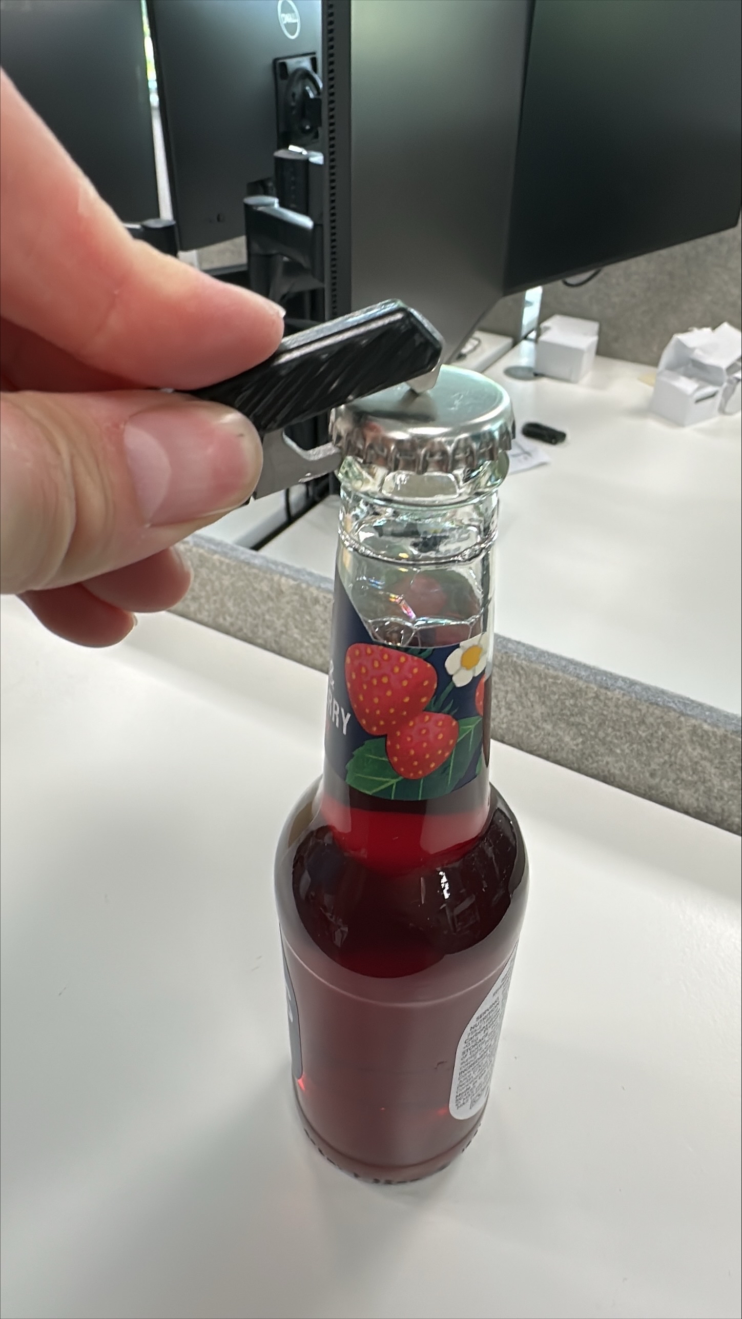 Engineer testing bottle opener prototype on a bottle