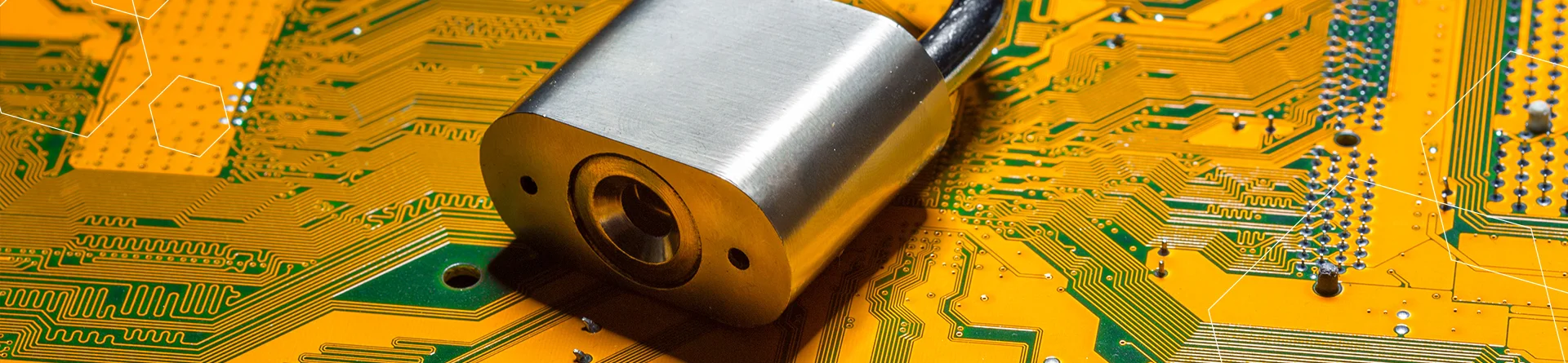 a silver padlock lying on top of a yellow and green pcb.