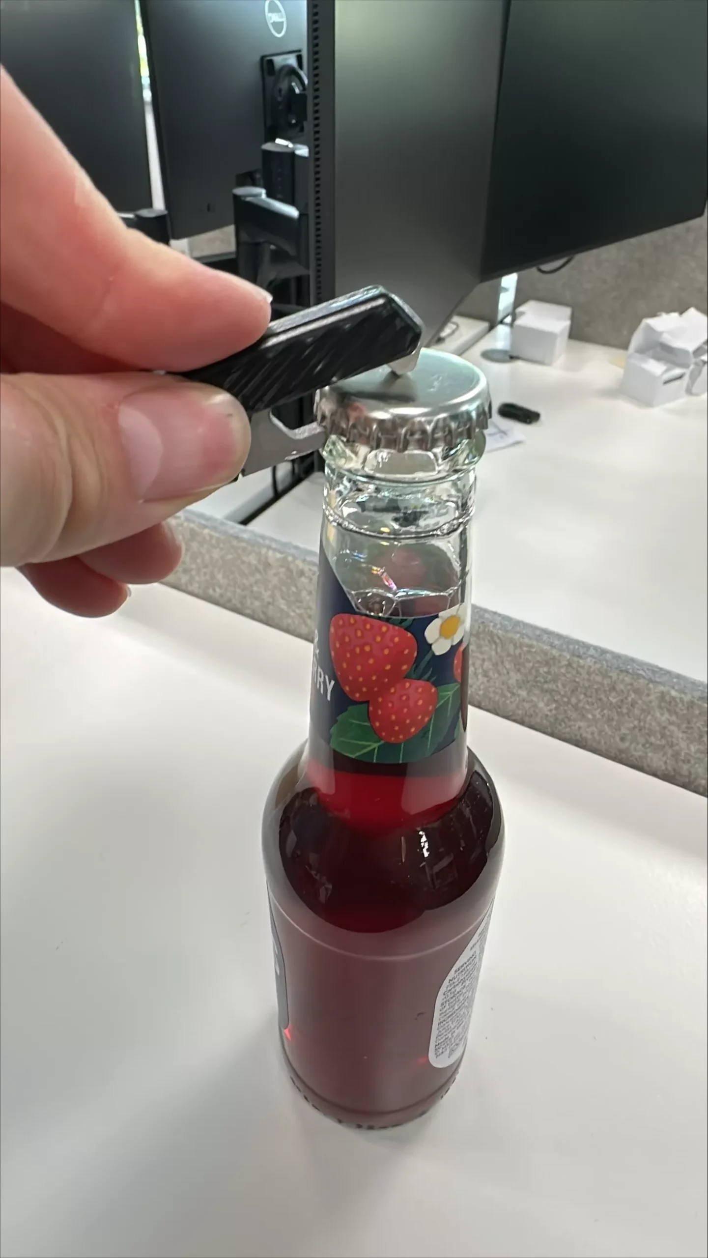 engineer testing bottle opener prototype on a bottle